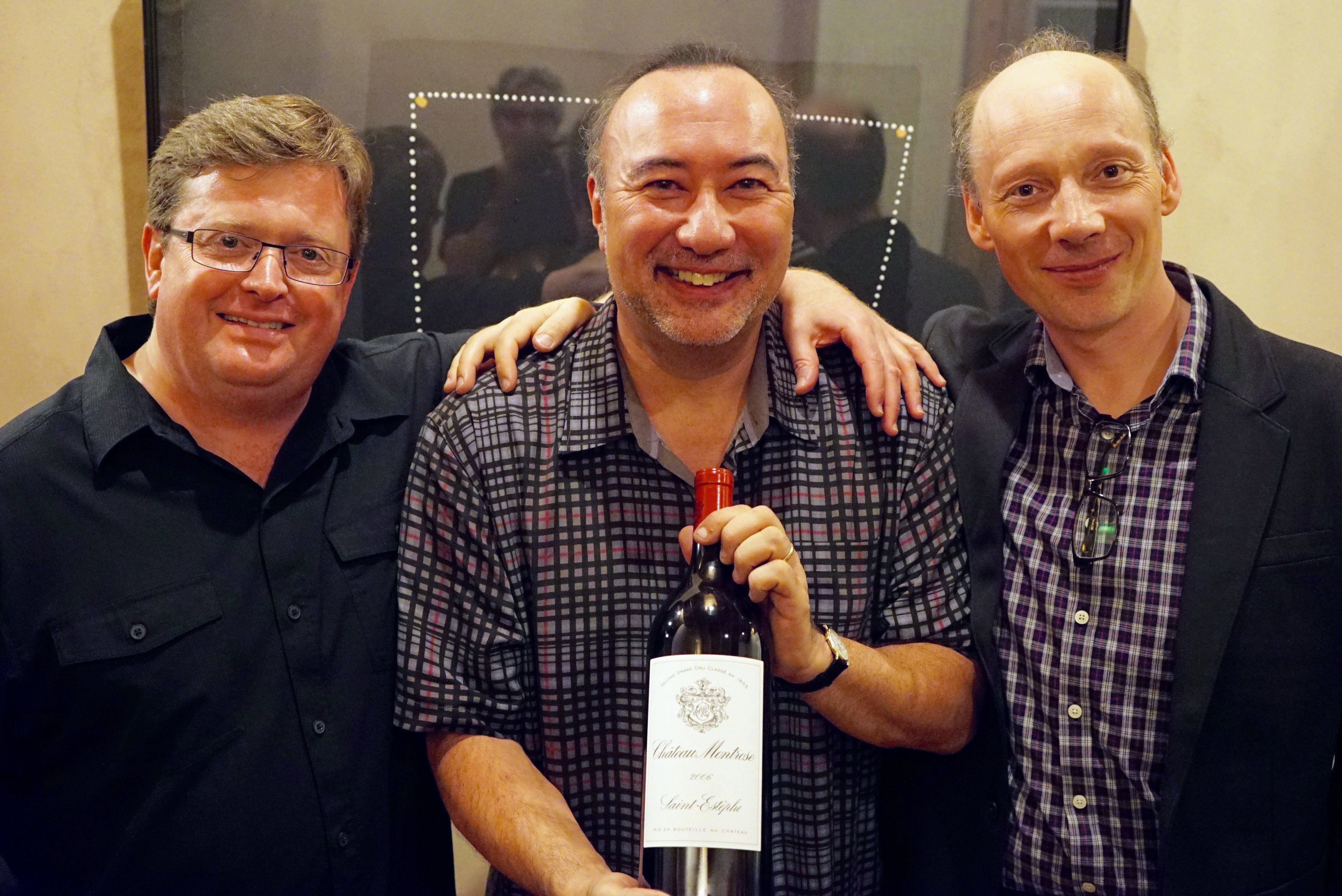 Martin Beaver, Jon Kimora Parker and Clive Greensmith with a bottle of their favorite wine, Chateau Montrose